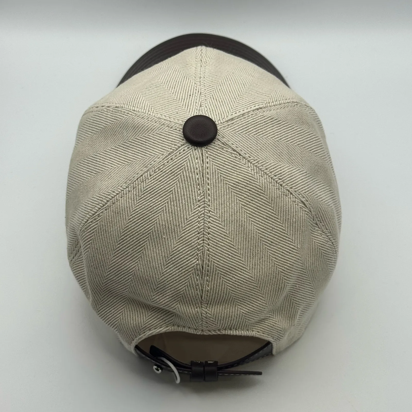 Berluti linen cap, top-down view showing the six-panel herringbone linen crown.