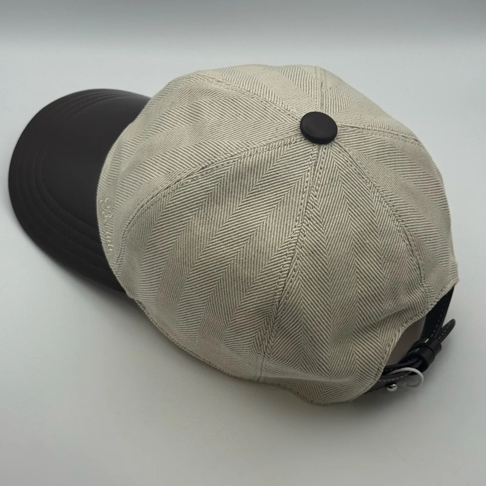Berluti linen cap, angled rear view showing the crown seams and dark brown brim edge.