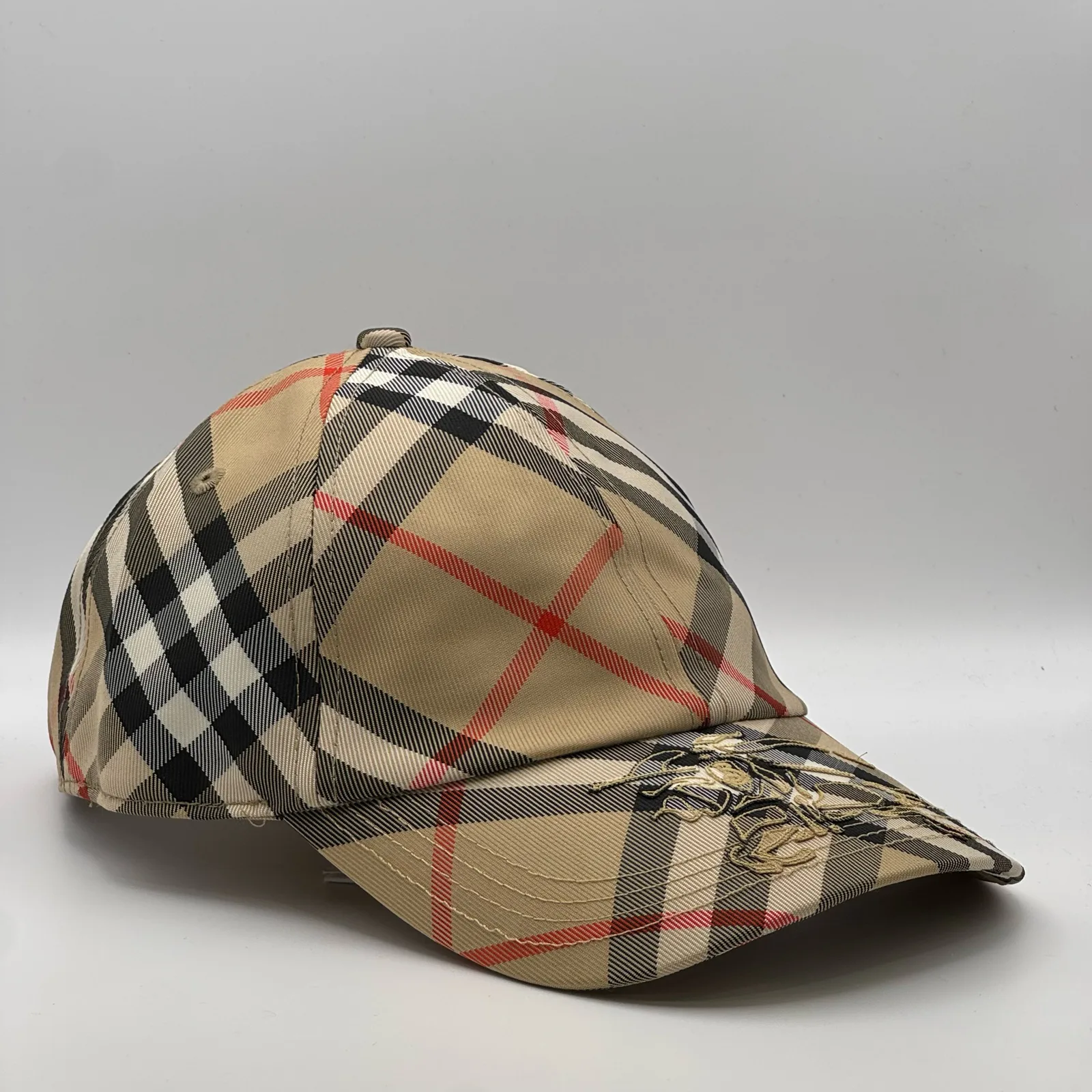 Beige check Burberry cap, three-quarter front-left view.