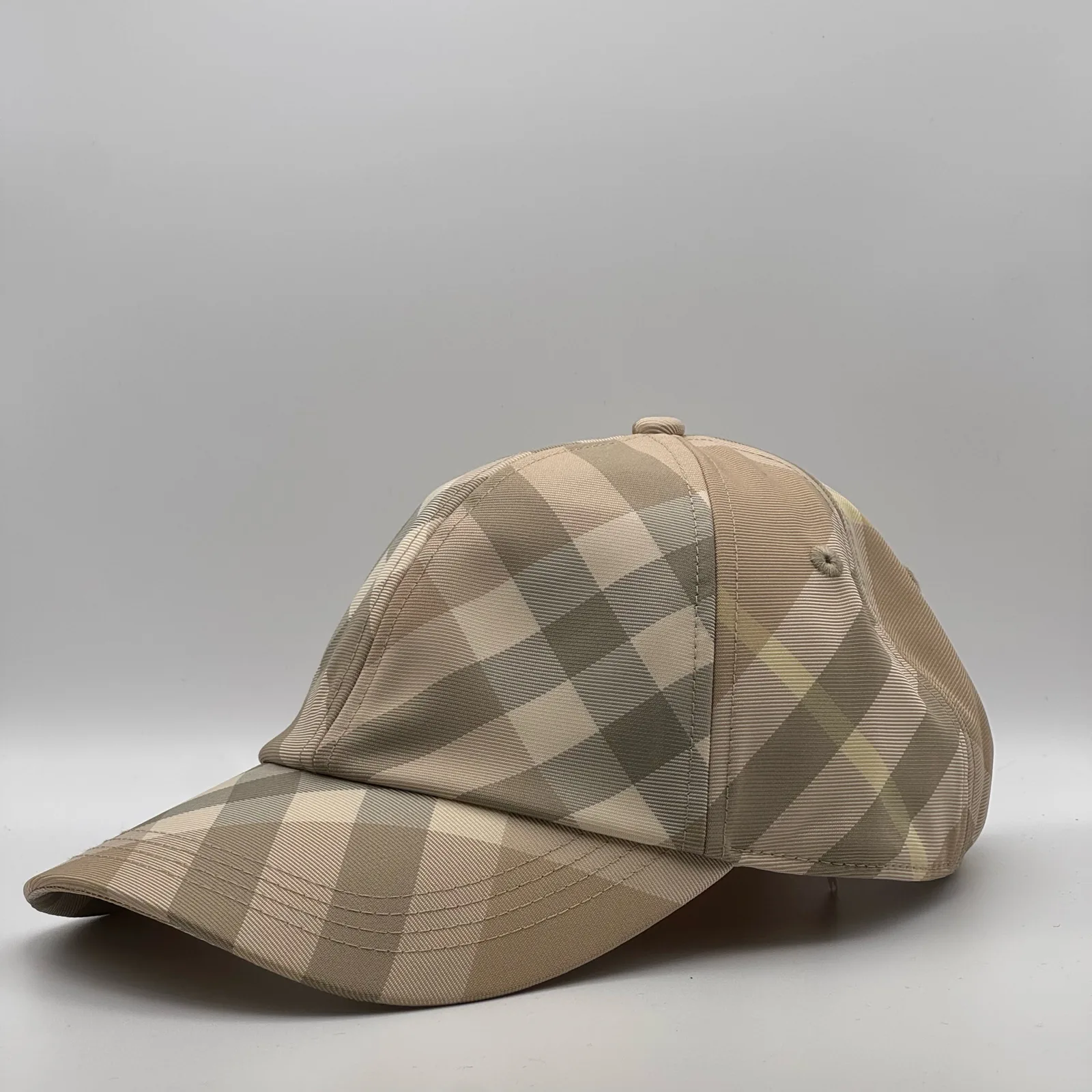 Pale beige check Burberry cap, three-quarter front-right view.
