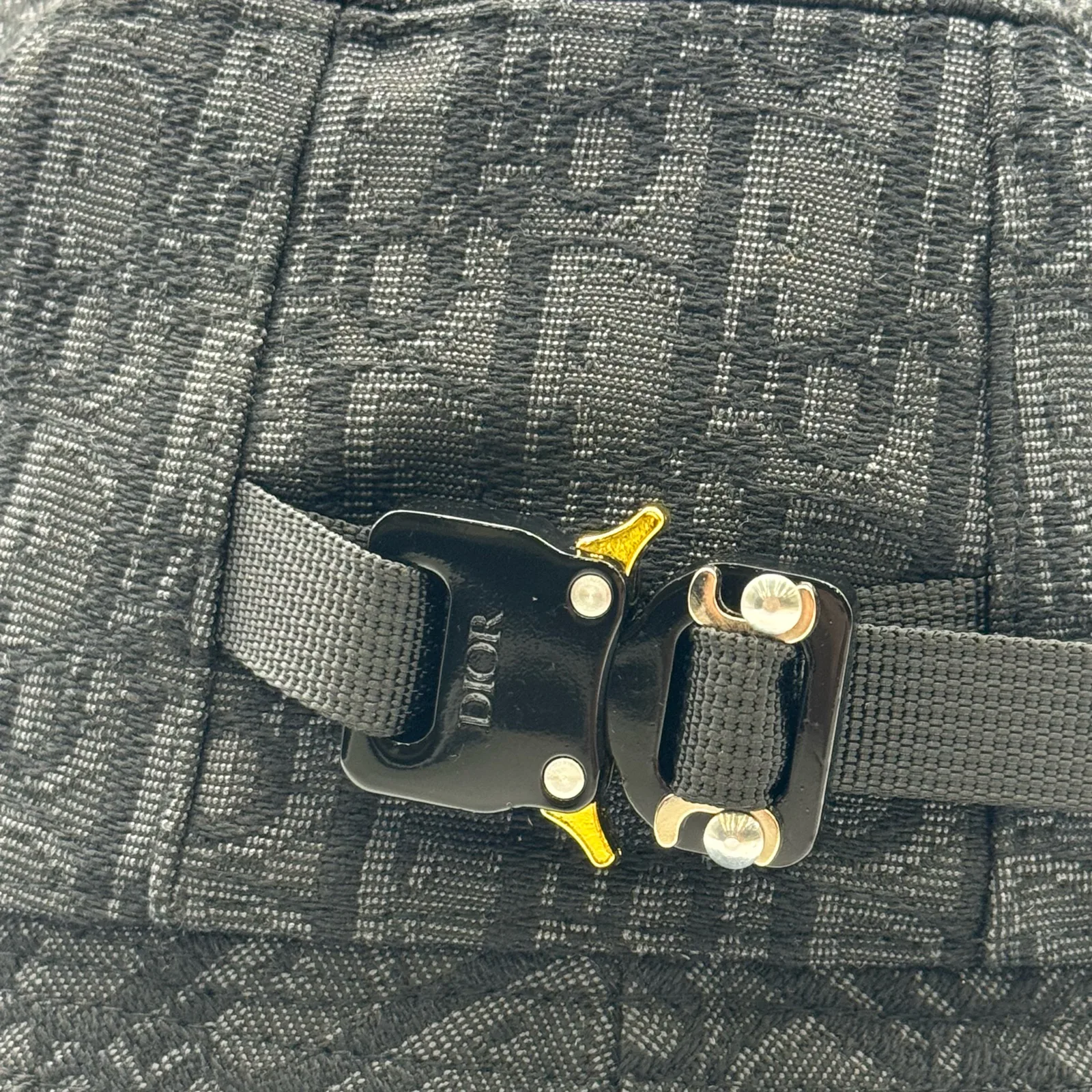 Close-up of the buckle hardware on the black Dior Oblique bucket hat.