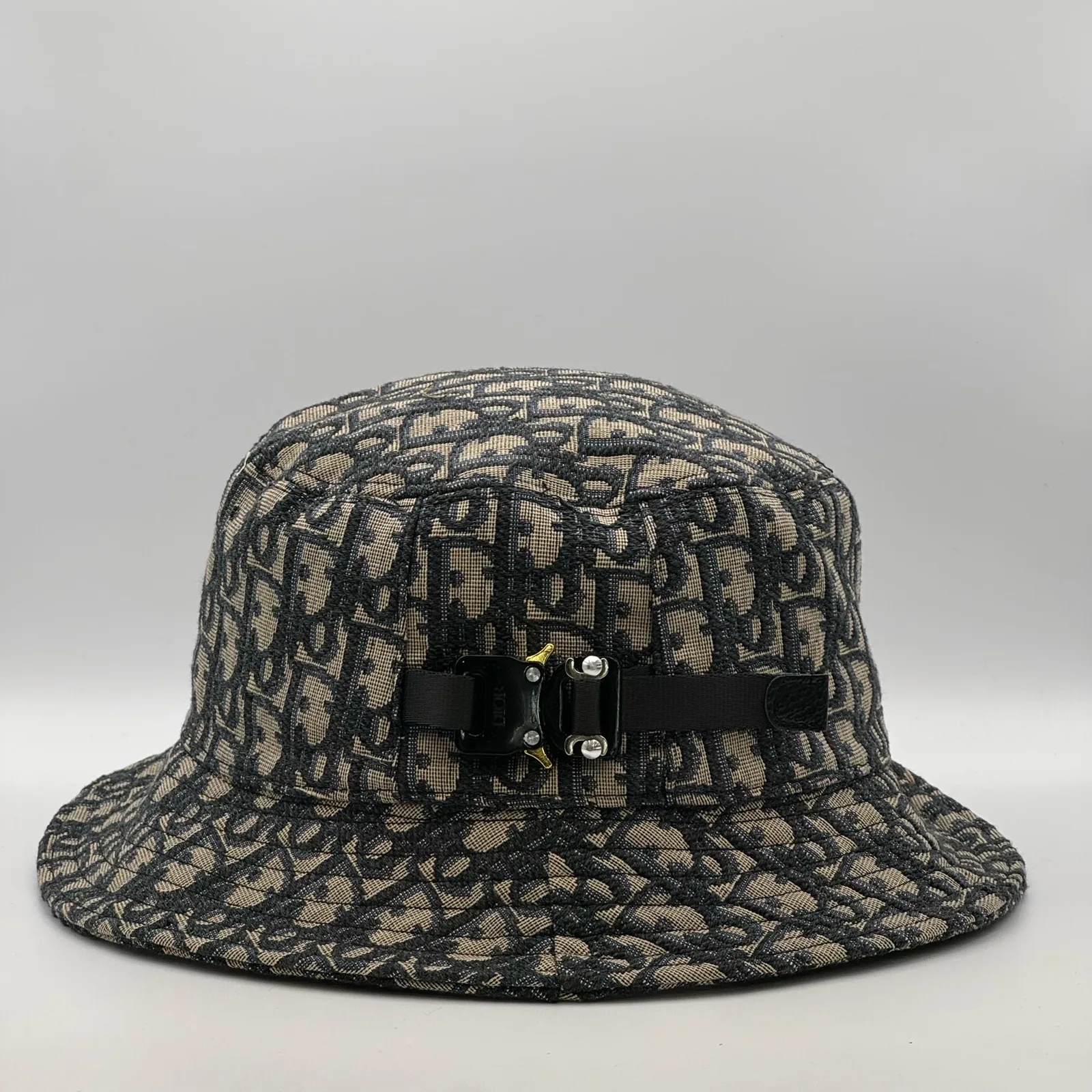 Dior Oblique bucket hat in navy and beige, side view showing the buckle strap.