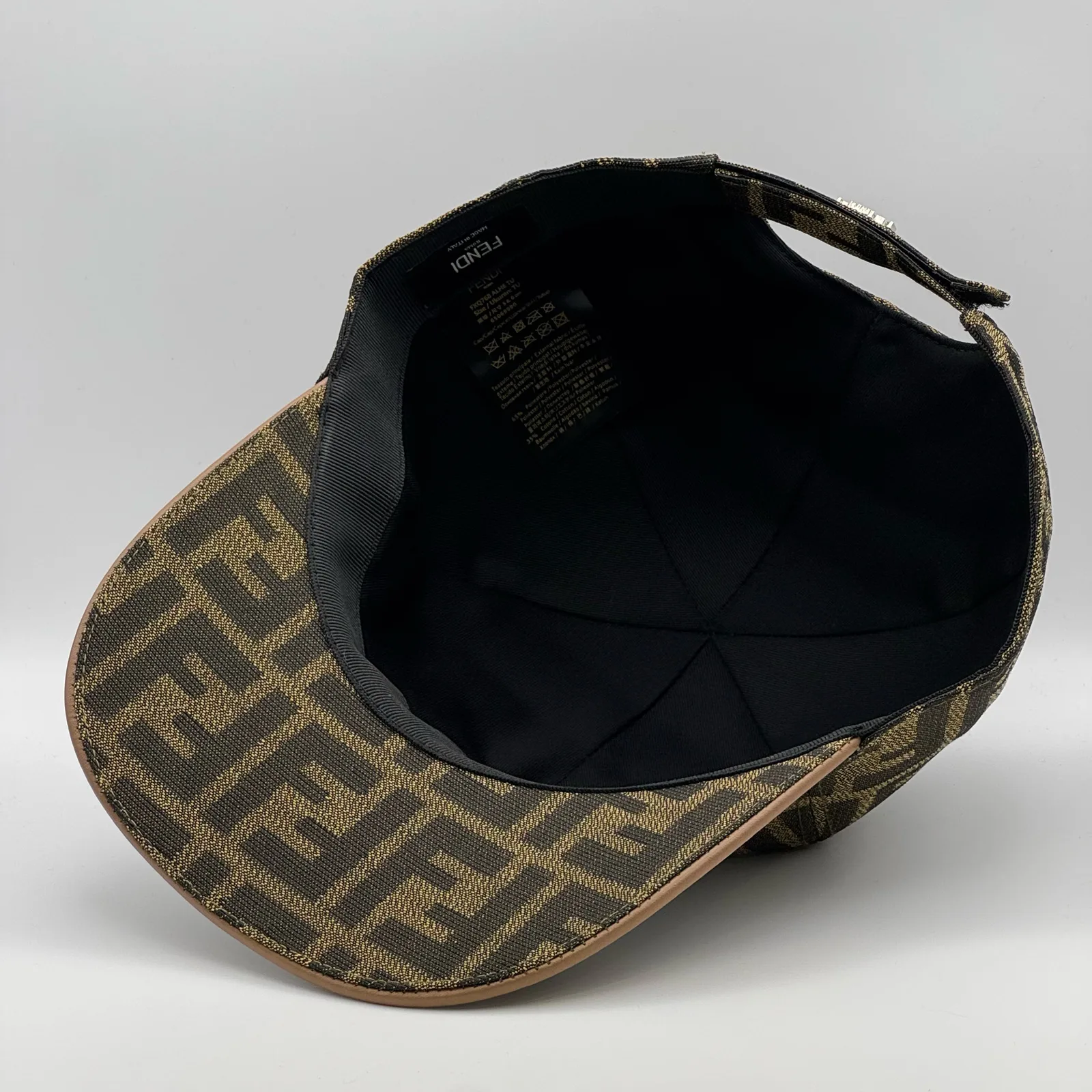 Underside of the brown FF cap, brim lifted to show the black interior and brand tag.