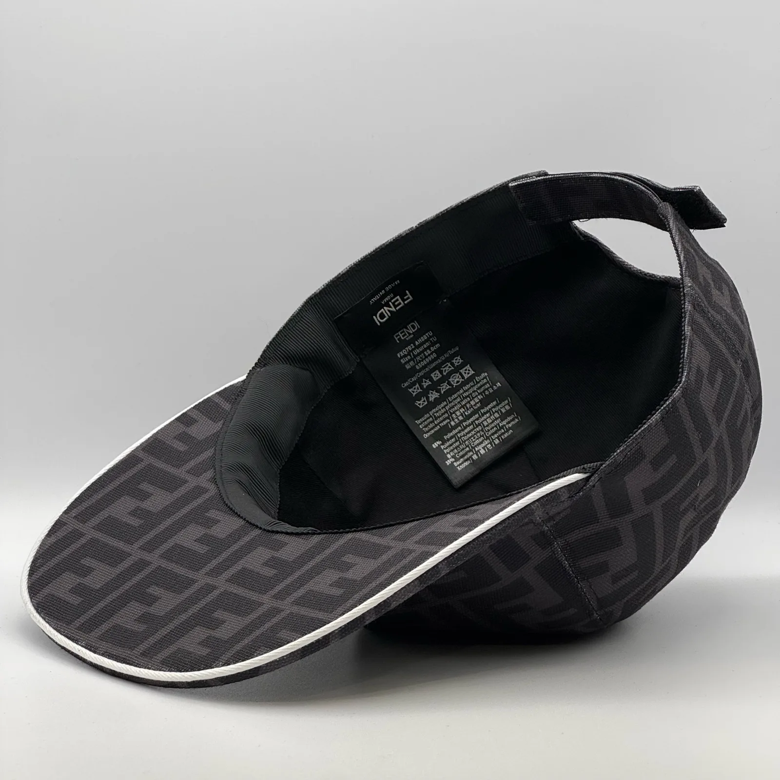 Close-up of the Fendi brand tag inside the dark grey FF cap.