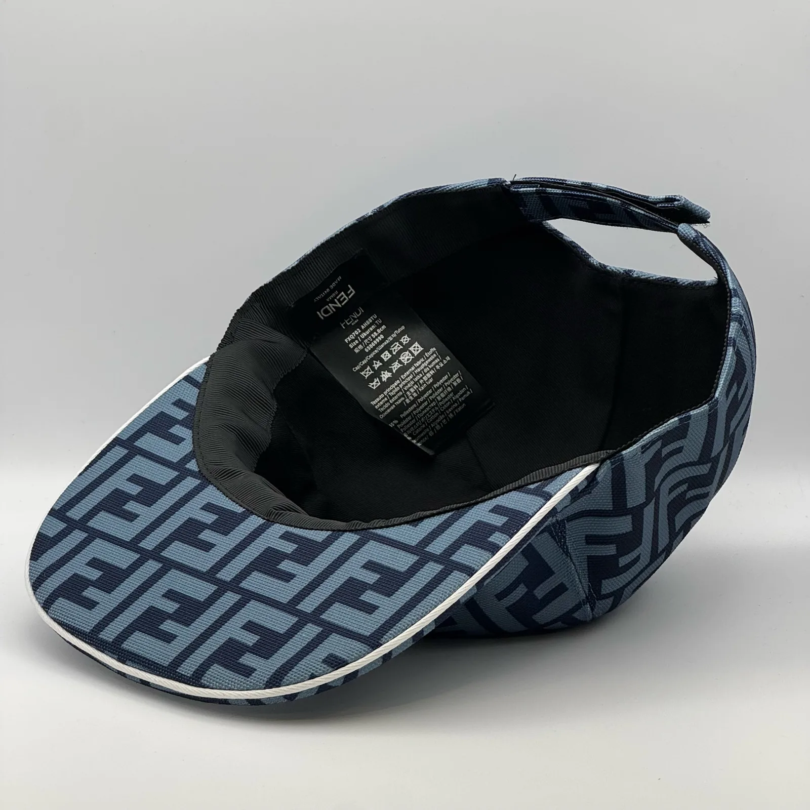 Close-up of the Fendi brand tag inside the navy blue FF cap.