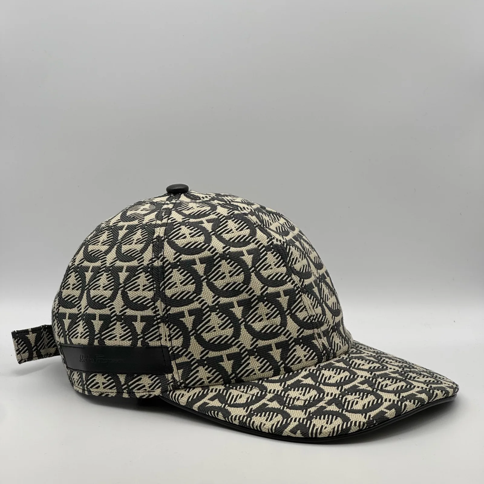 Ferragamo Gancini cap, three-quarter view showing the strap tab at the side.