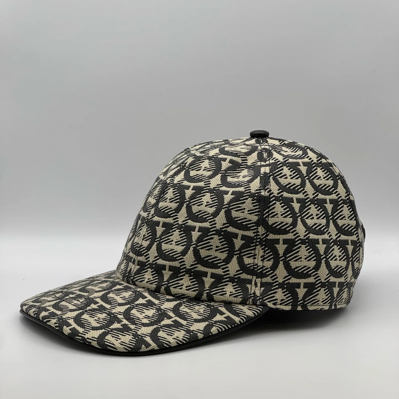 Ferragamo Gancini cap, side profile in the woven Gancini print with black trim.