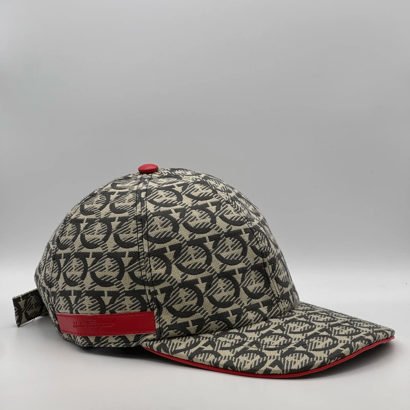 Ferragamo Gancini cap, three-quarter view showing the strap tab at the side.