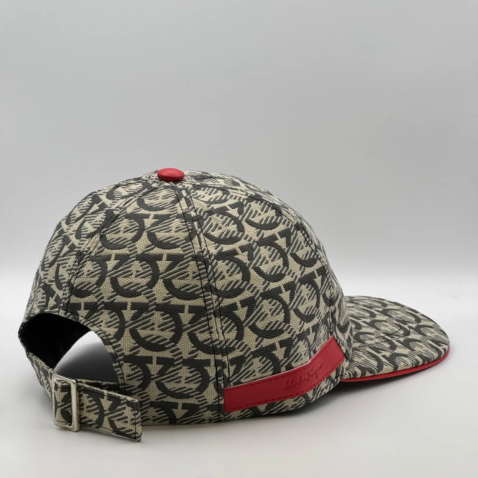 Ferragamo Gancini cap, back profile showing the strap buckle and red trim along the band.