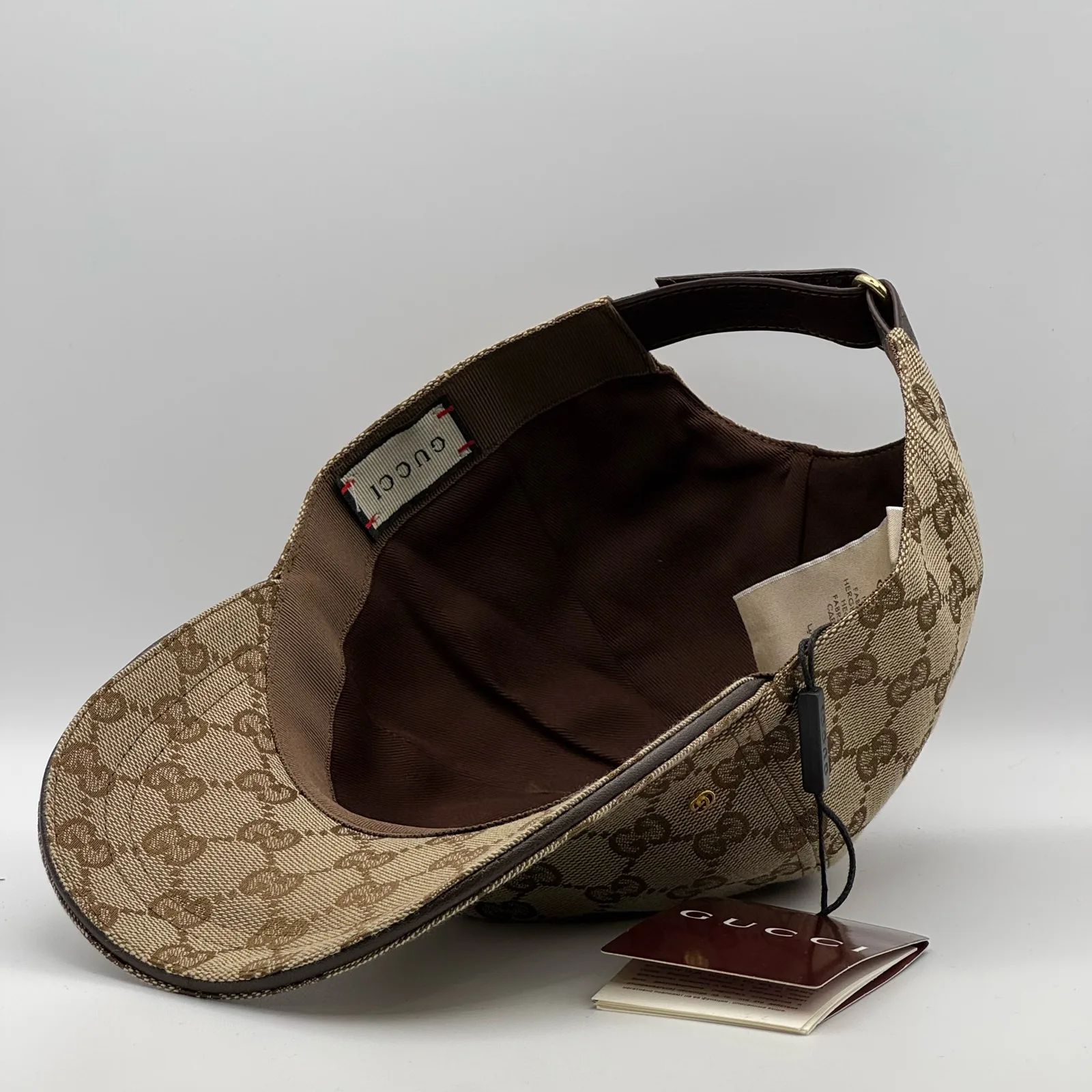 Beige GG canvas cap, interior view with brand booklet and tag