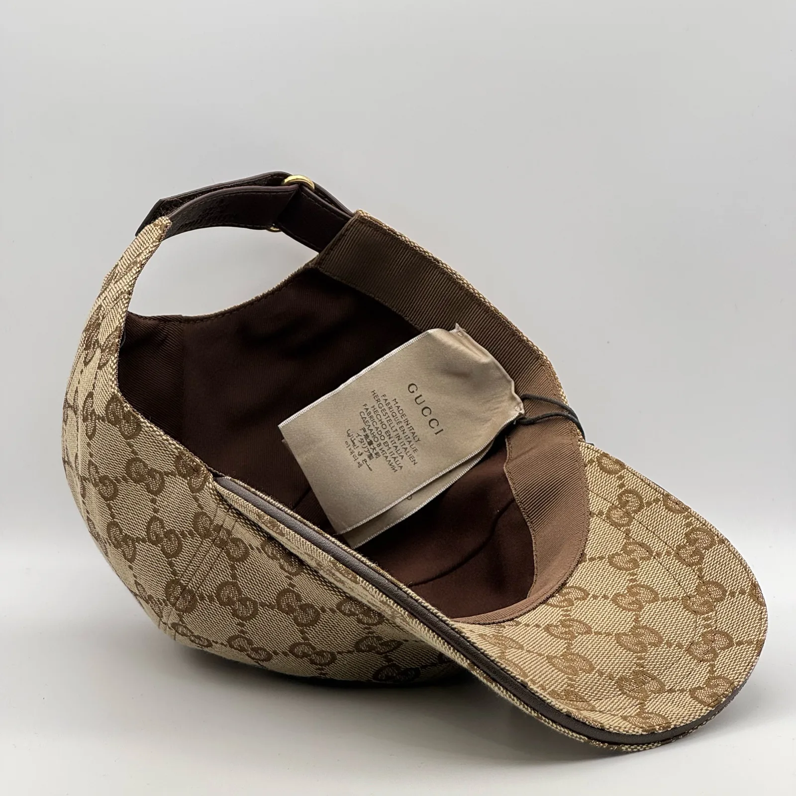 Beige GG canvas cap, interior view showing the brown lining and hanging tag