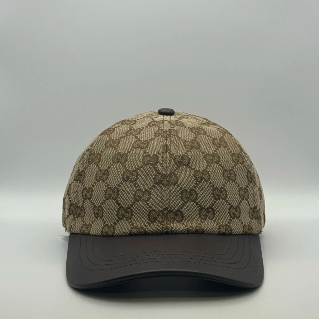 Beige GG canvas cap, front three-quarter view with a dark brown leather brim