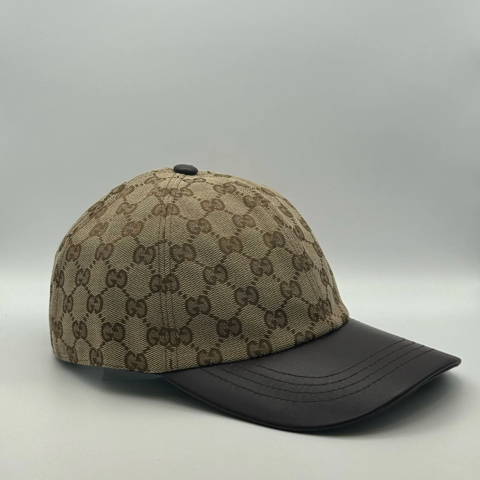 Beige GG canvas cap, side view showing the dark brown leather brim and strap