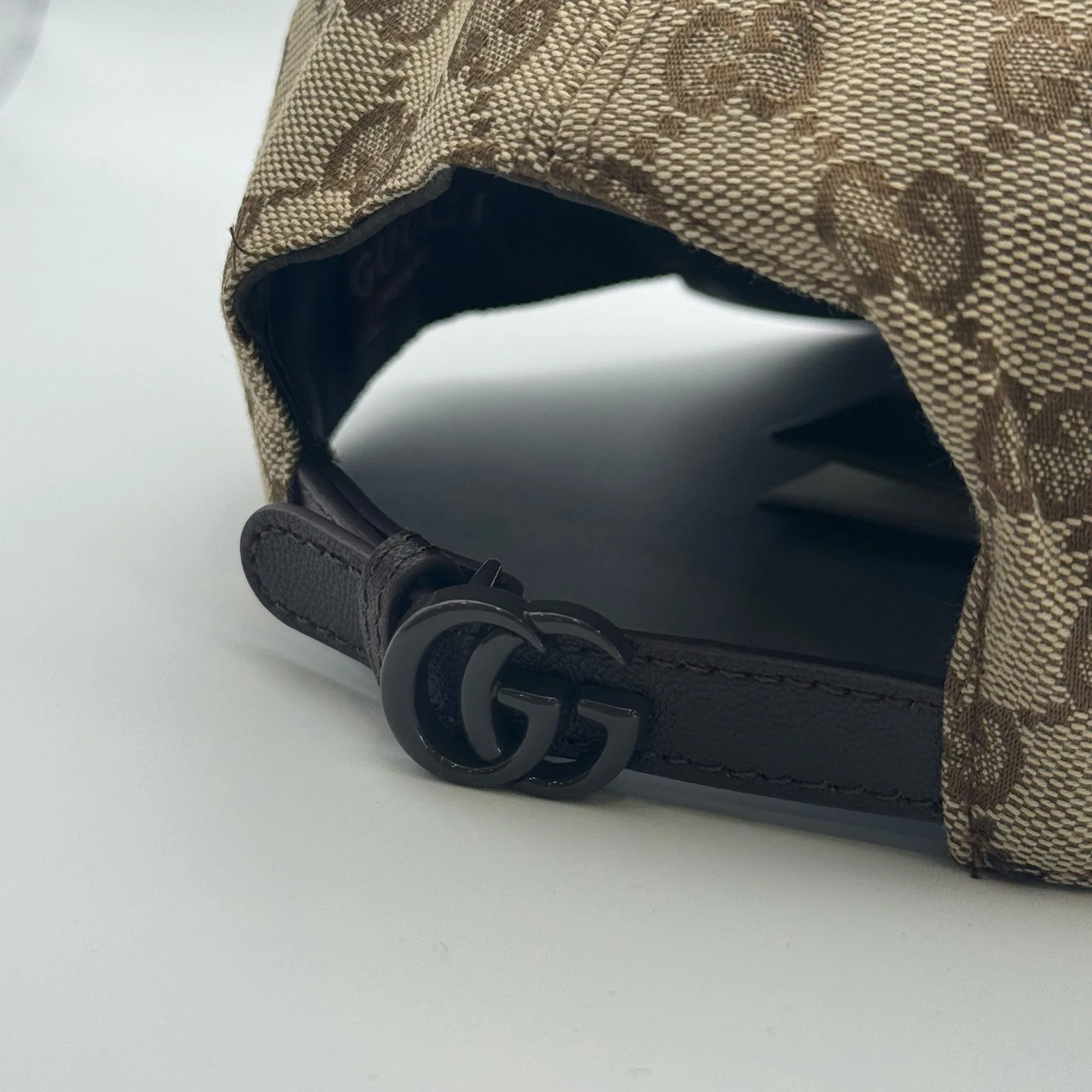 Beige GG canvas cap, underside view showing the brown lining and buckle strap