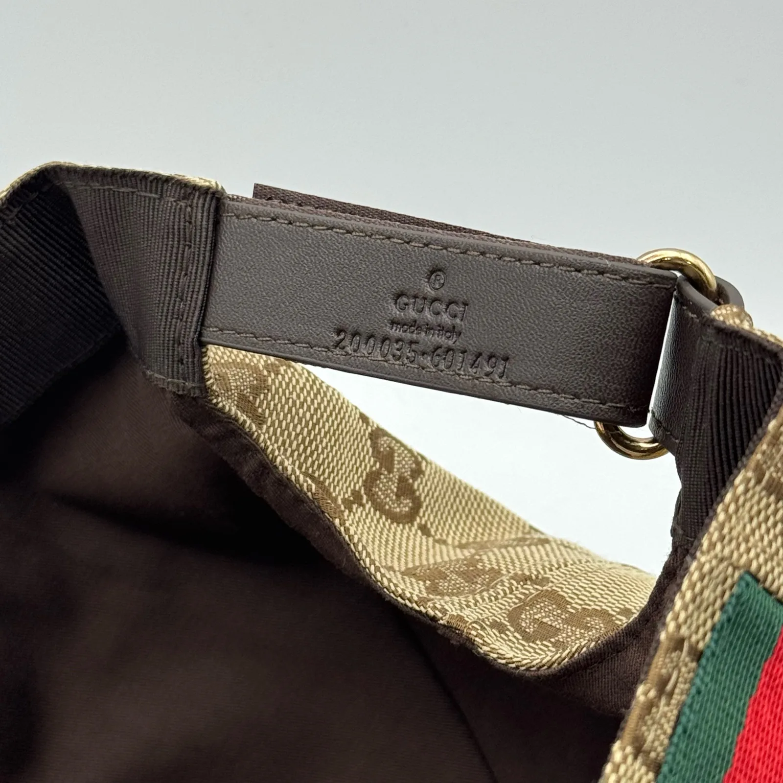 Beige GG canvas cap, close-up of the strap hardware and leather tab