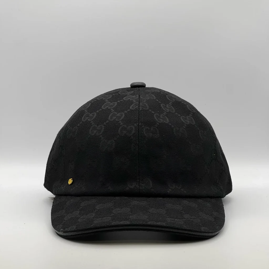 Black GG canvas cap, front three-quarter view with a small gold emblem on the crown