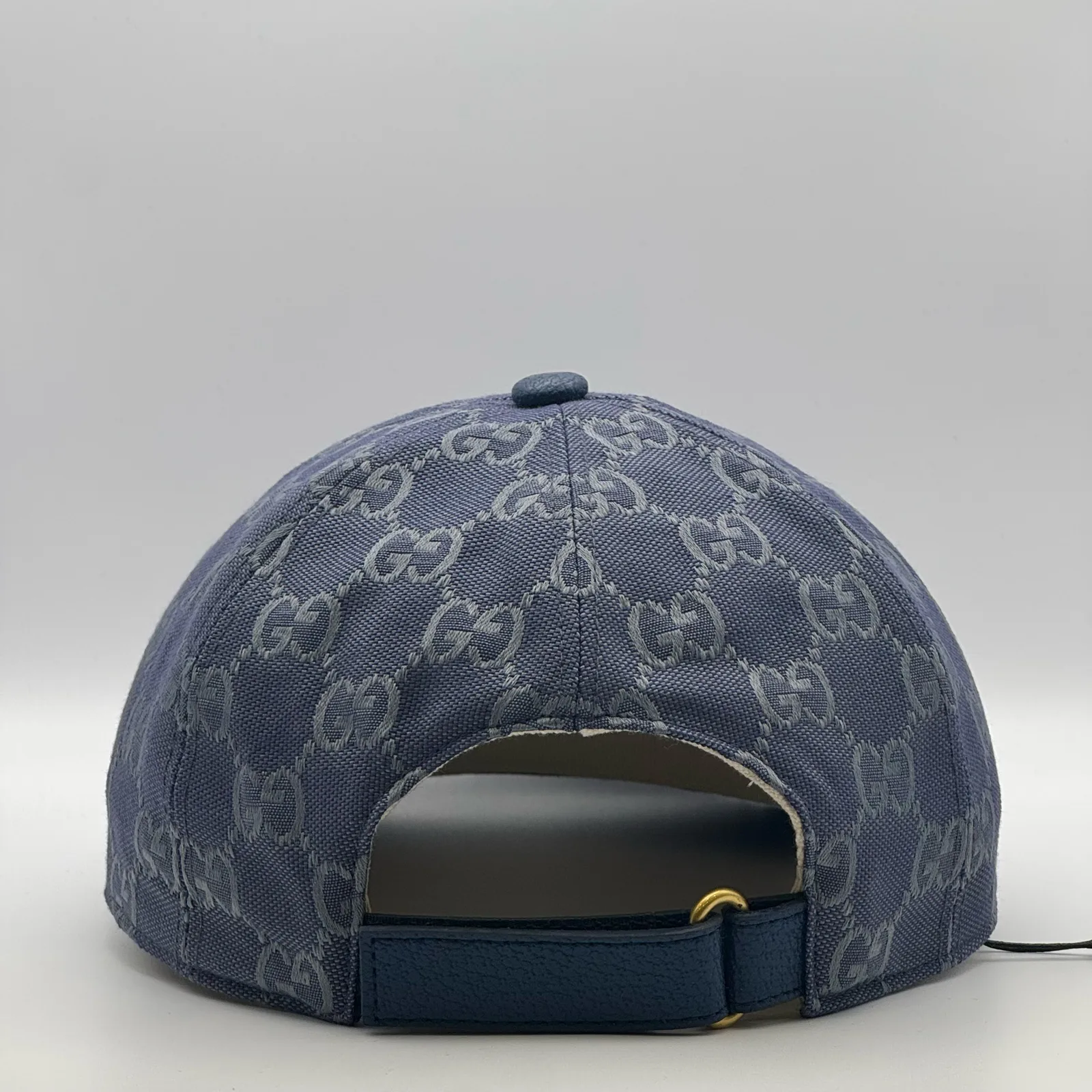 Denim blue GG canvas cap, back view with cream leather strap and gold buckle