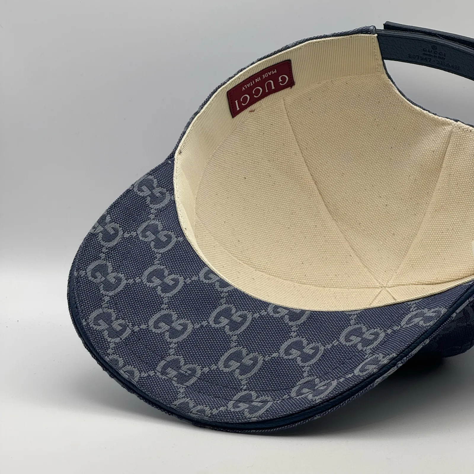 Denim blue GG canvas cap, interior view showing the cream lining and hanging tag