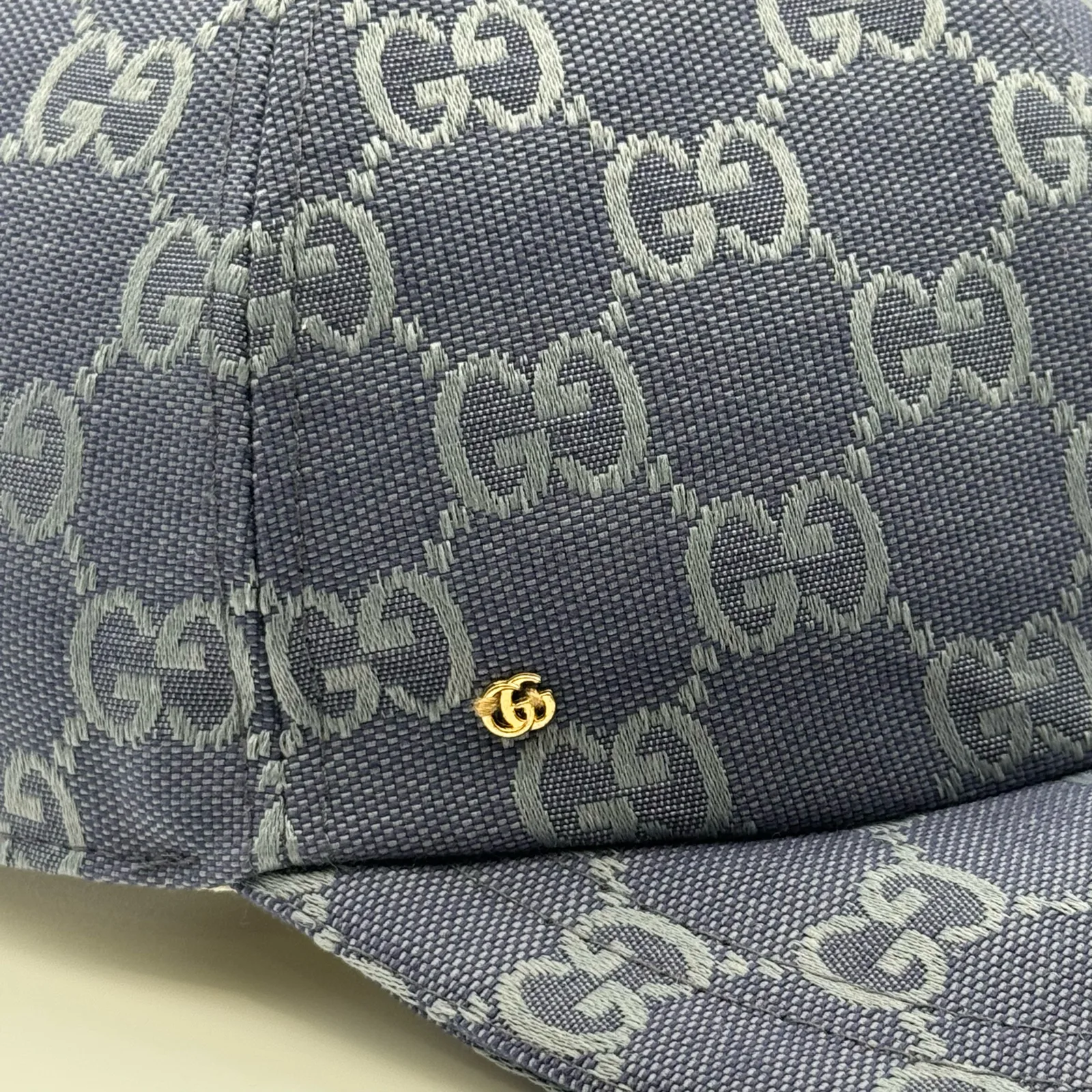 Denim blue GG canvas cap, close-up of the canvas weave and gold logo hardware