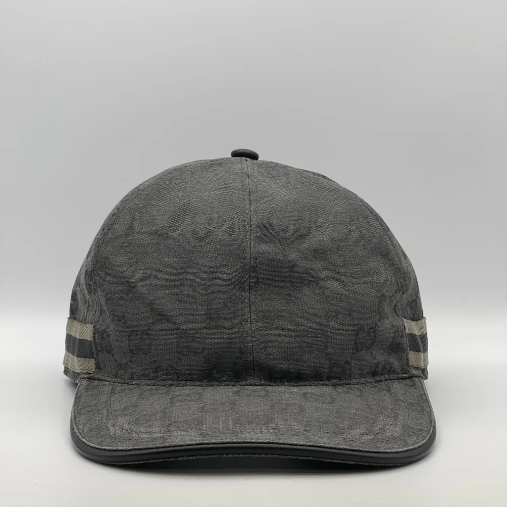 Charcoal grey GG canvas cap, front three-quarter view with a tan and black web stripe