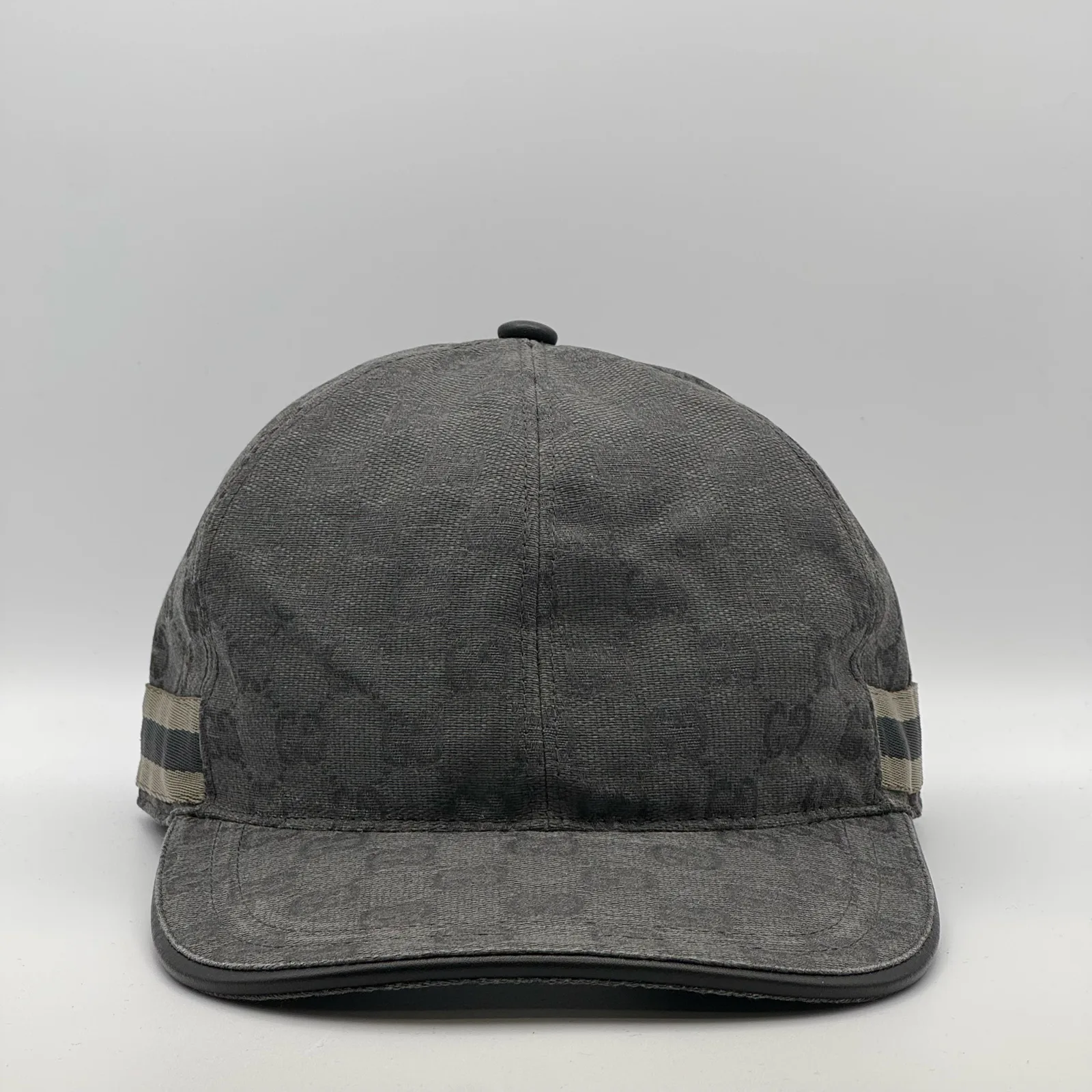 Charcoal grey GG canvas cap, front three-quarter view with a tan and black web stripe