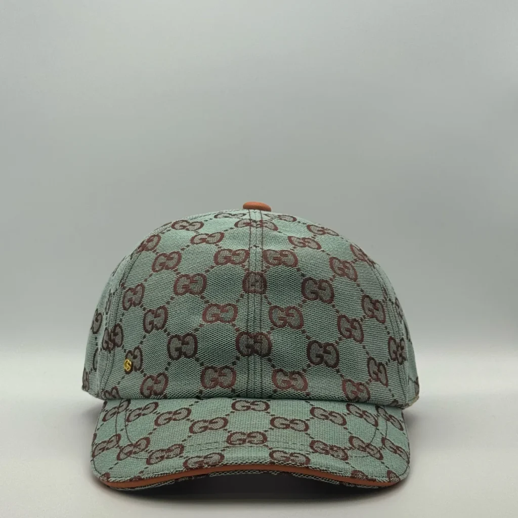Mint green GG canvas cap, front three-quarter view with tan leather brim and orange trim