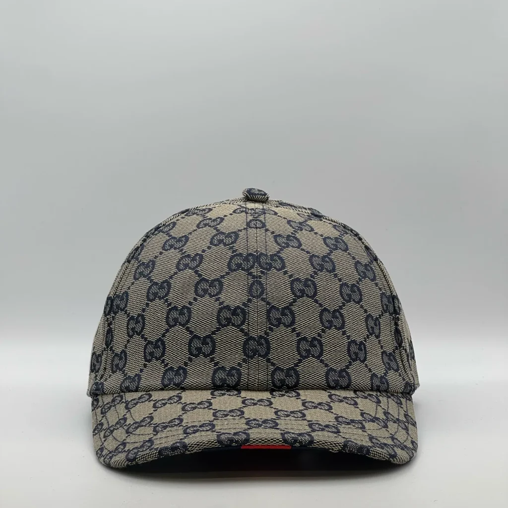 Navy and beige GG canvas cap, front three-quarter view with red web stripe trim