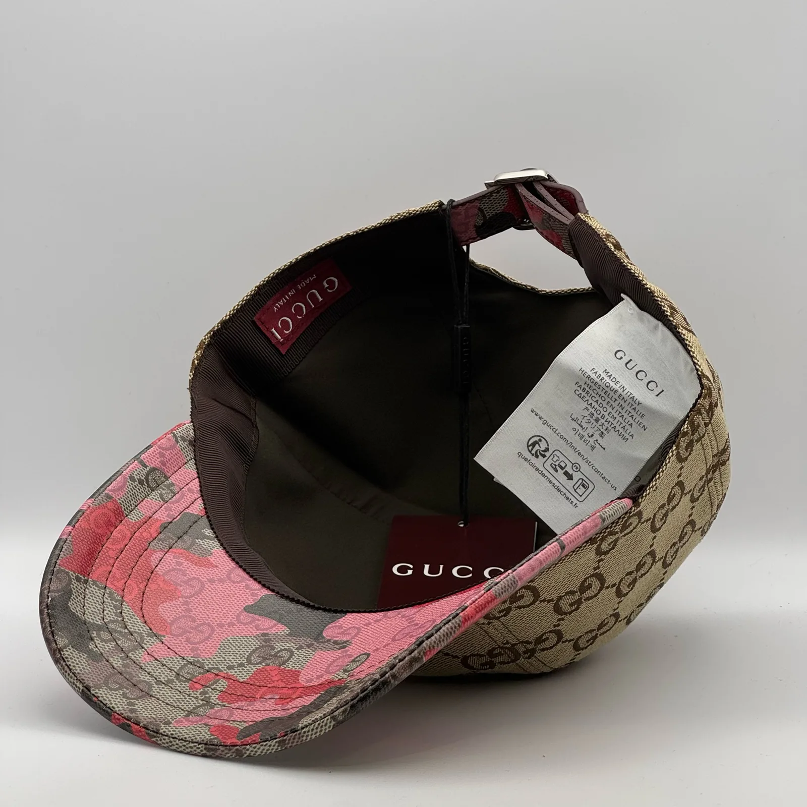 Beige GG canvas cap, brim lifted showing the pink and olive floral underside