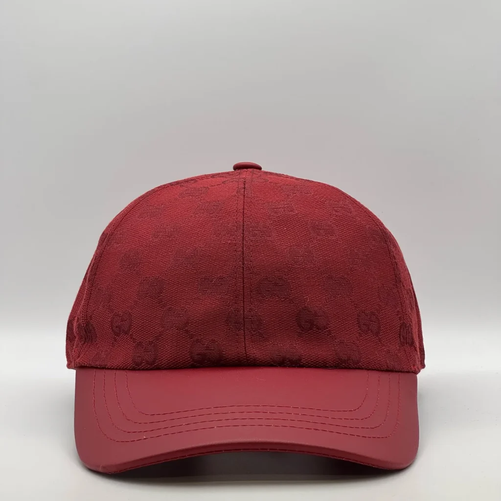 Deep red GG canvas cap, front three-quarter view with a matching red leather brim