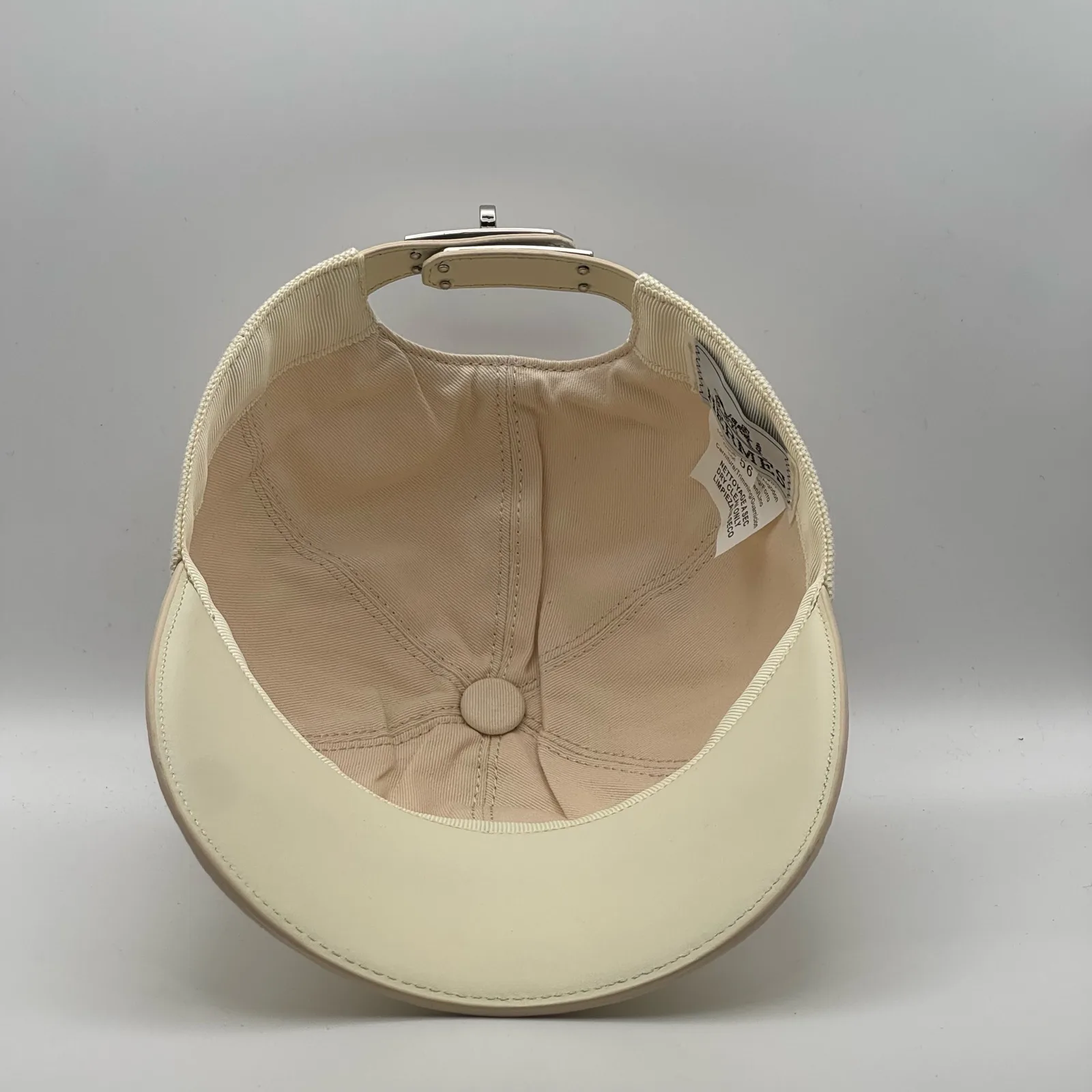 Hermès canvas cap, underside view showing the cream interior lining and brim.