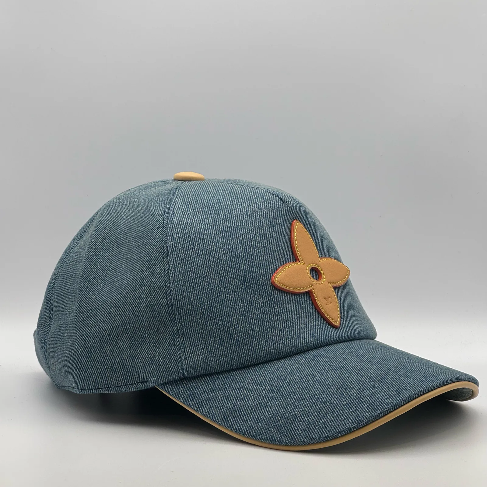 Blue denim flower cap, three-quarter side view.
