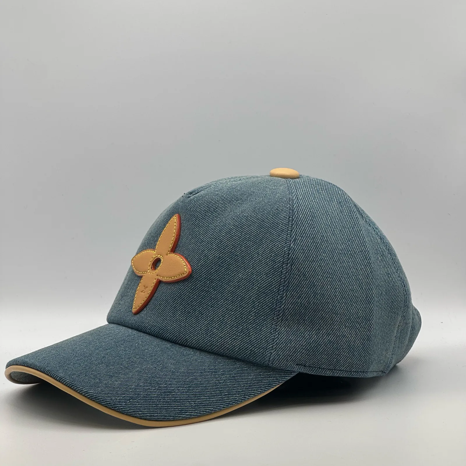 Blue denim flower cap, side profile view.