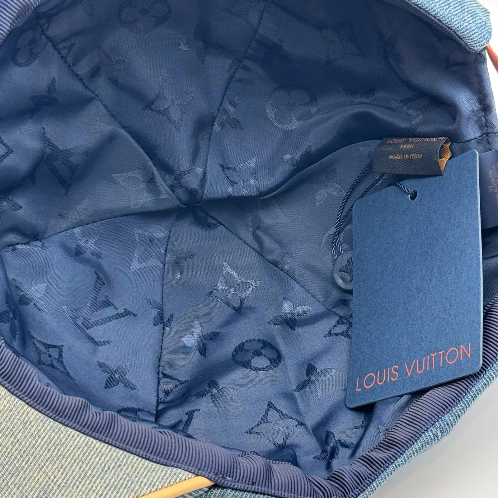 Inside view of the blue denim cap showing the lining and brand tag.