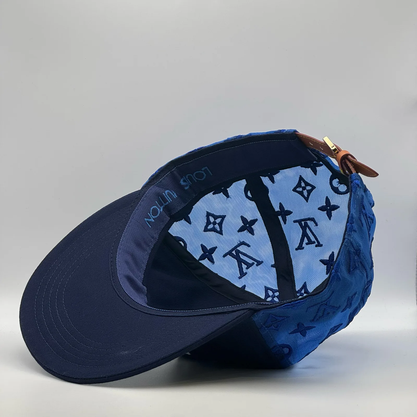 Angled view of the navy logo mesh cap showing the strap and lining.
