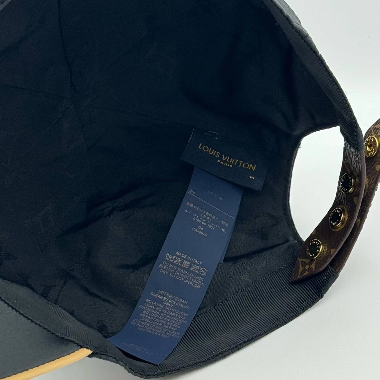 Inside view of the black cap showing the brand tape and strap.