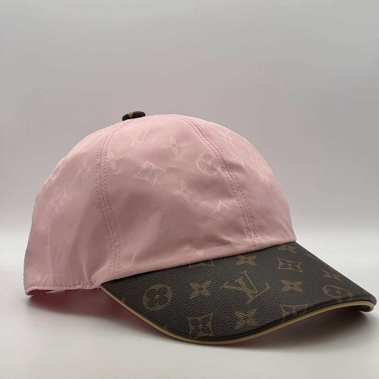 Pink monogram brim cap, side profile view.