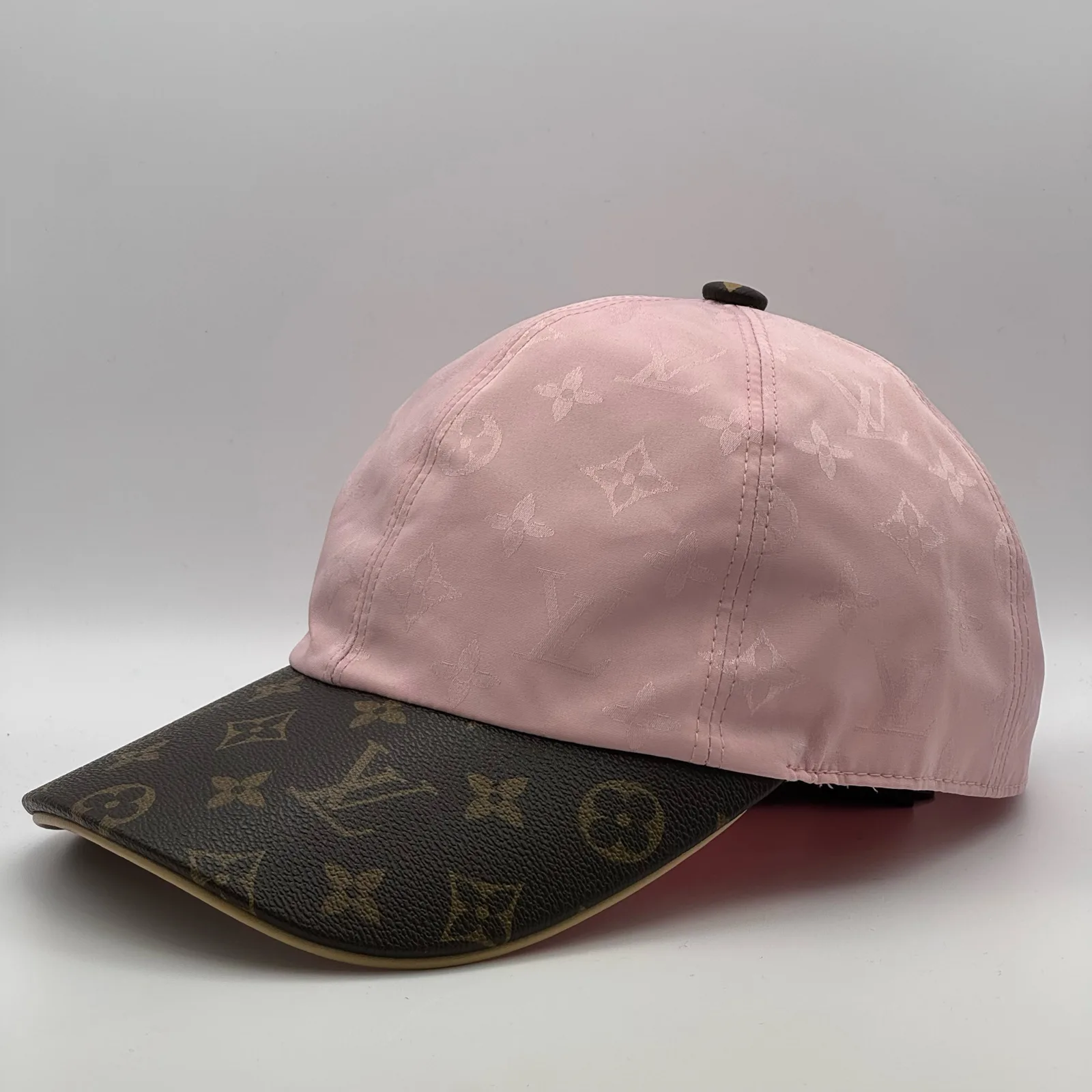 Pink monogram brim cap, angled side view.