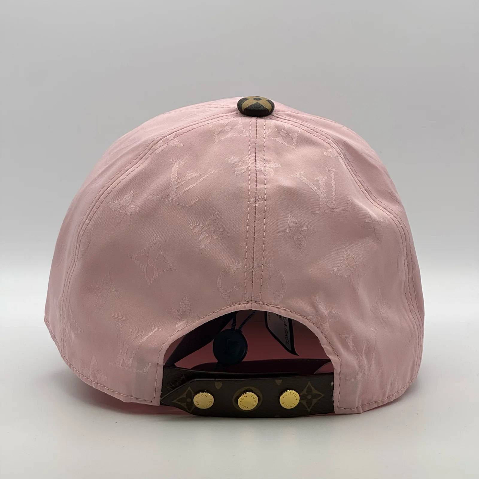 Pink monogram brim cap, back view showing the gold snap-stud closure.