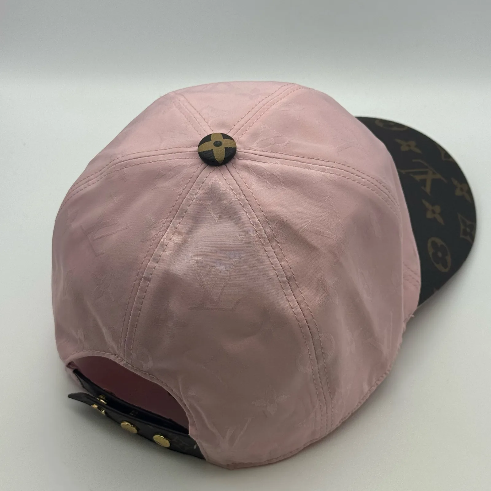 Pink monogram brim cap, three-quarter back view.