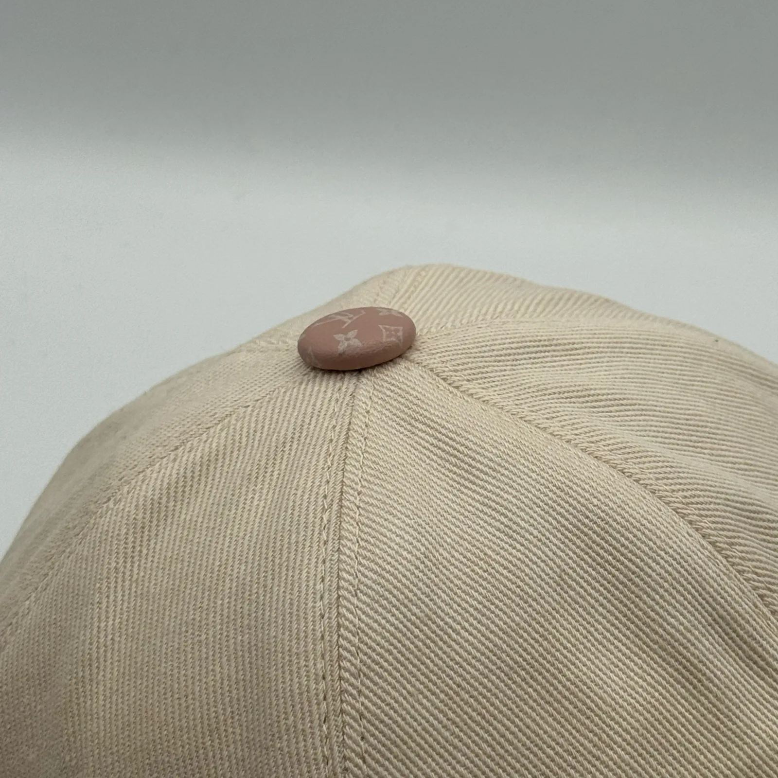 Beige flower cap, top-down view showing the crown button.