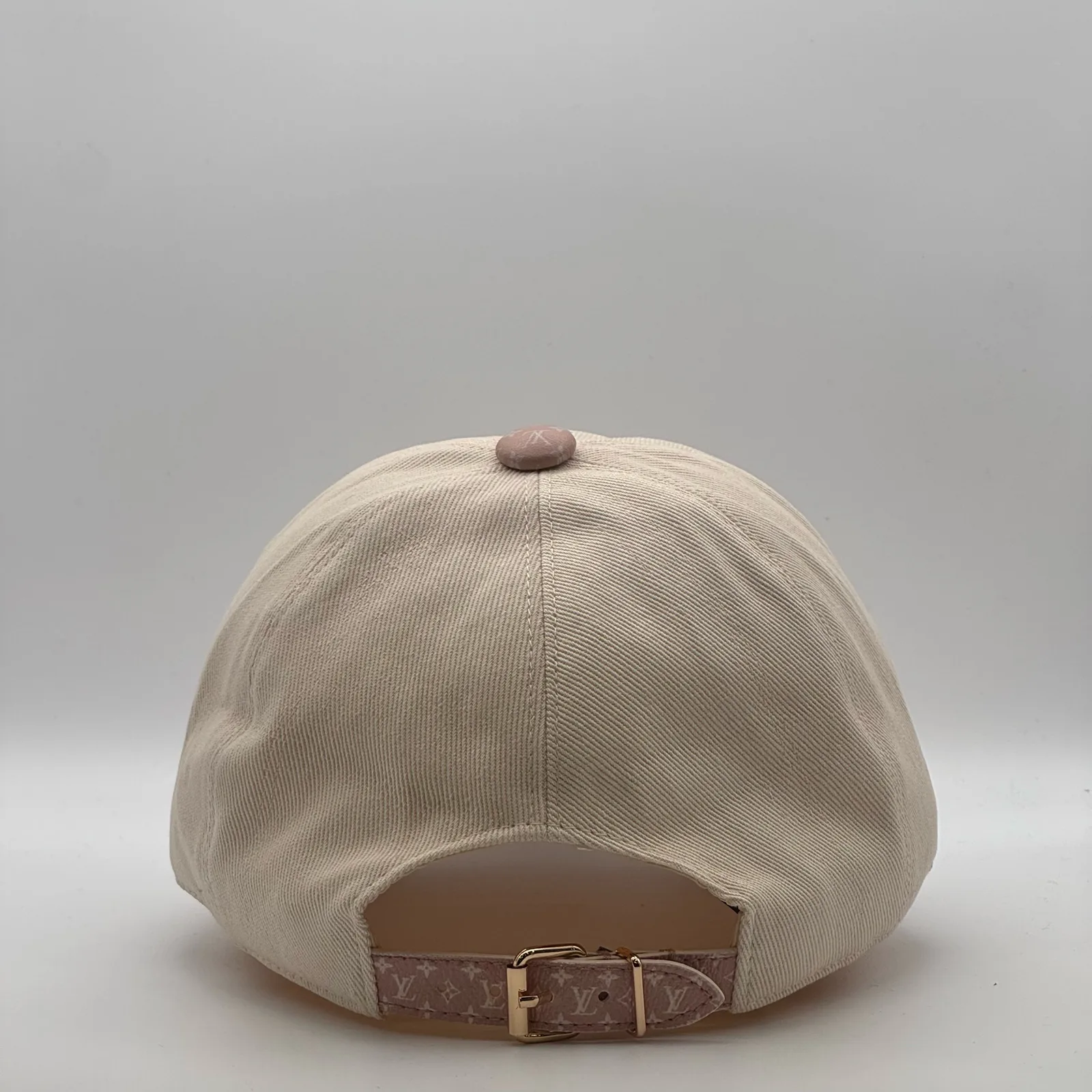 Beige flower cap, back view showing the adjustable leather strap.
