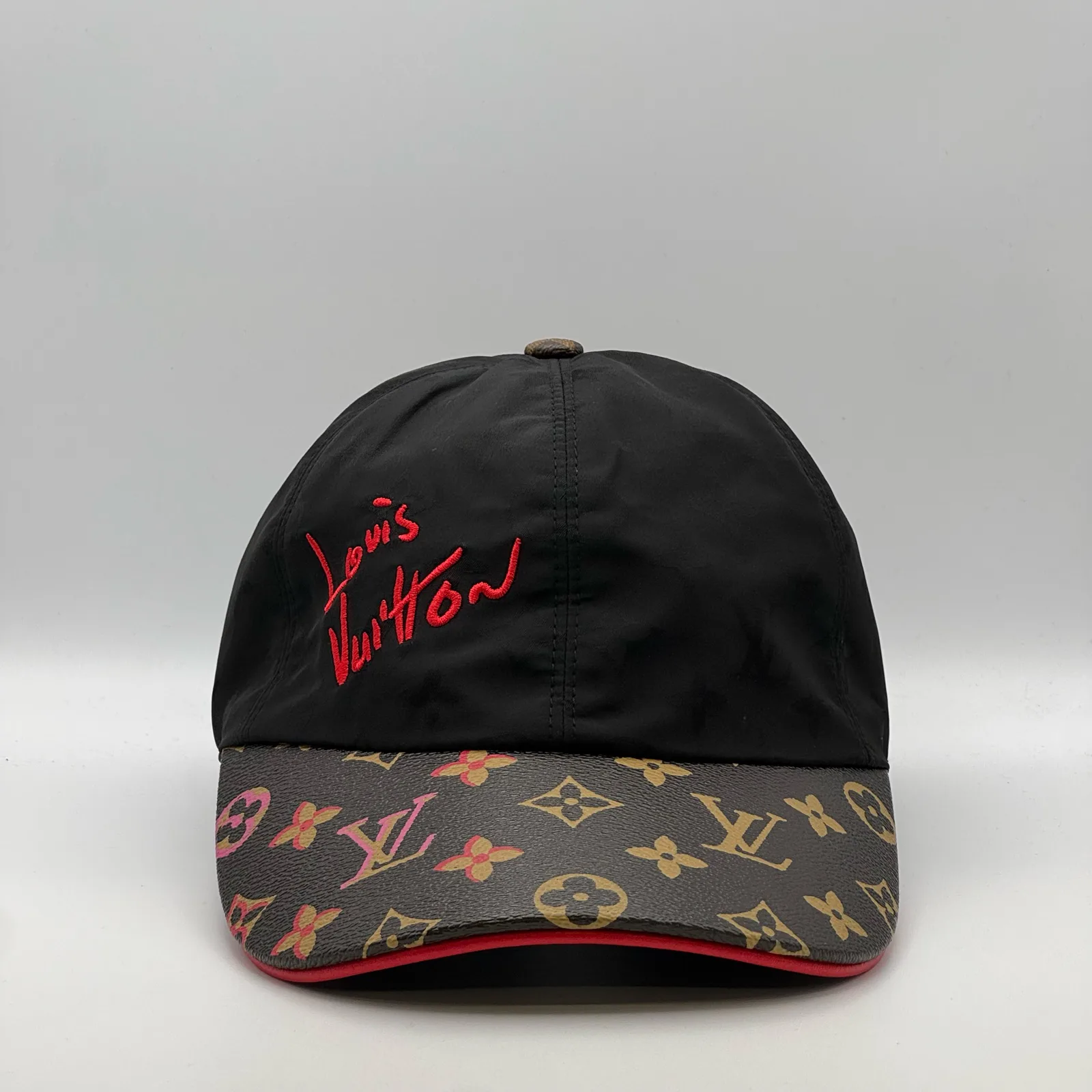 Black Louis Vuitton Signature cap, three-quarter view showing the red script logo and monogram brim.