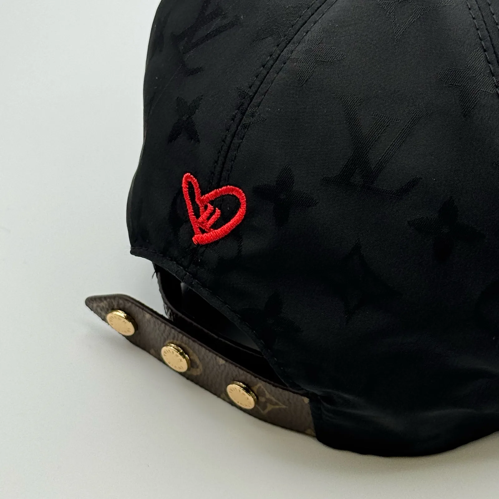Close-up of the red heart embroidery and strap closure.