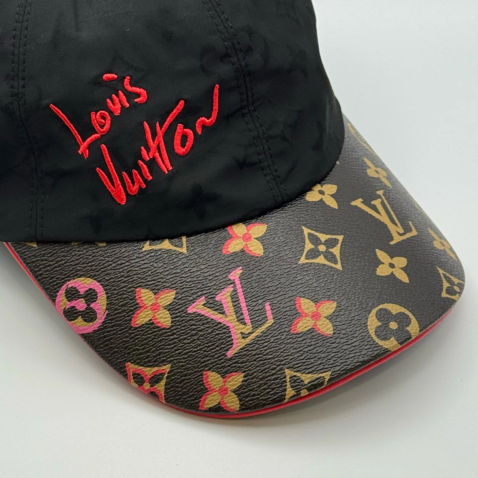 Close-up of the pink and orange monogram print on the brim.